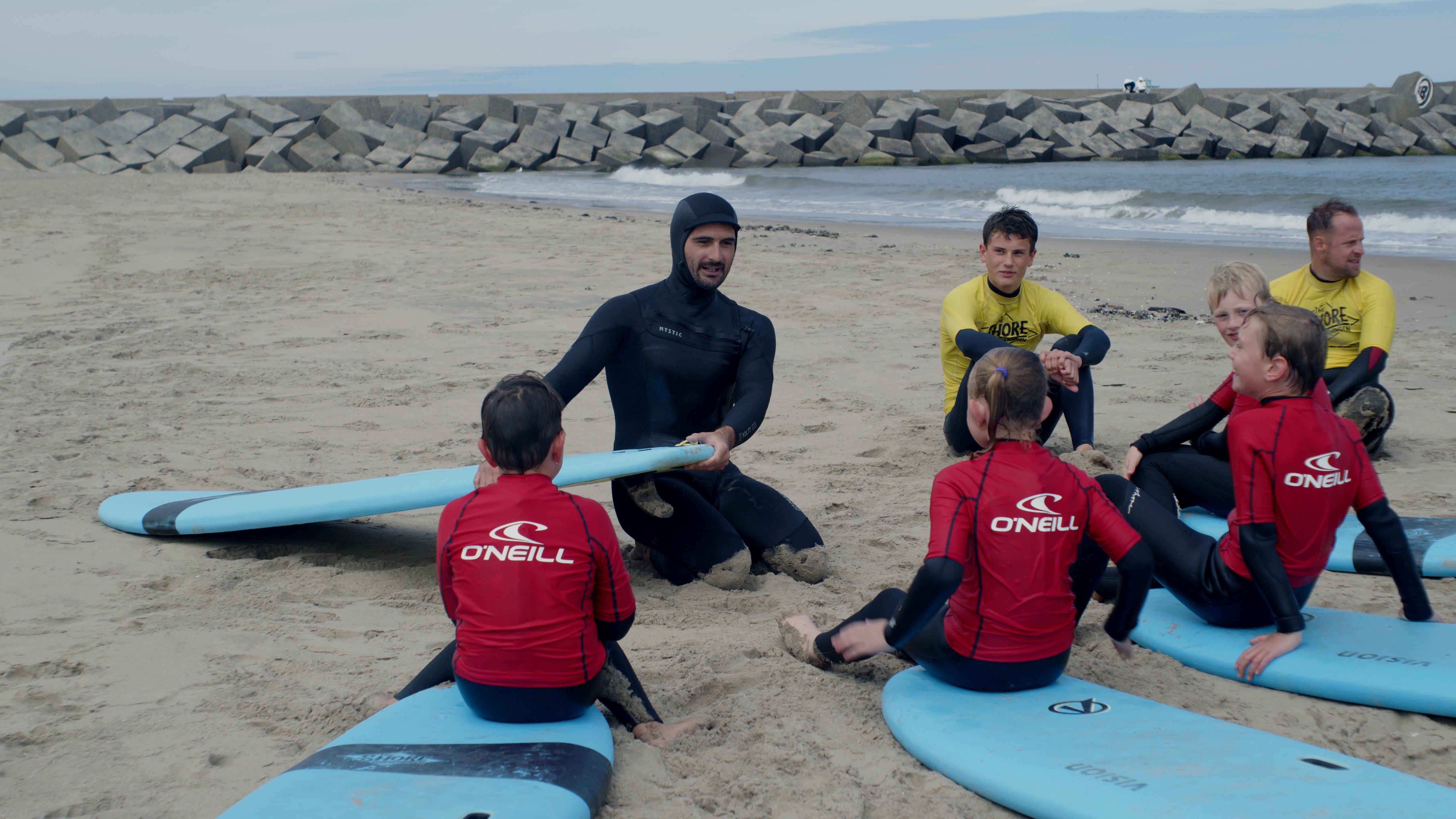 Sacha aan zee, met een surfboard onder zijn arm.